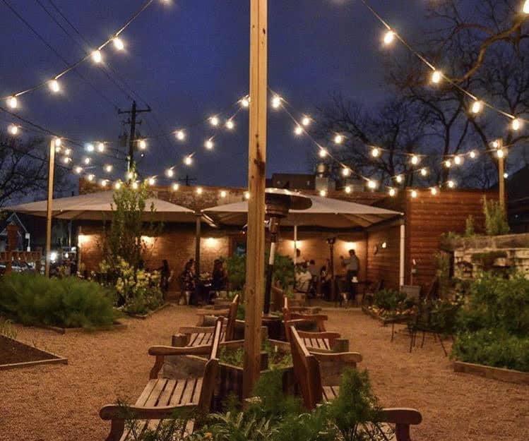 A business' outdoor patio lit up with string lights and other patio lighting