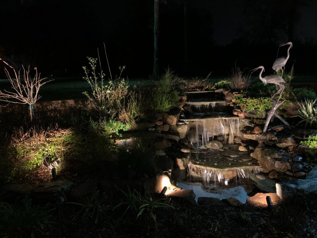 Outdoor Lights Illuminate Water Feature At Night