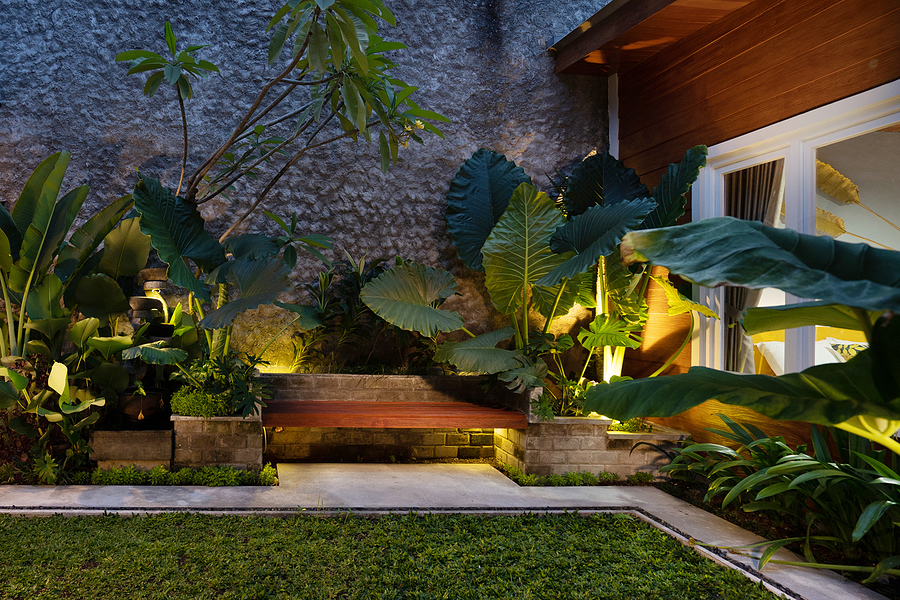 Outdoor Lighting Illuminates Resort like Backyard landscape & walkway with bench
