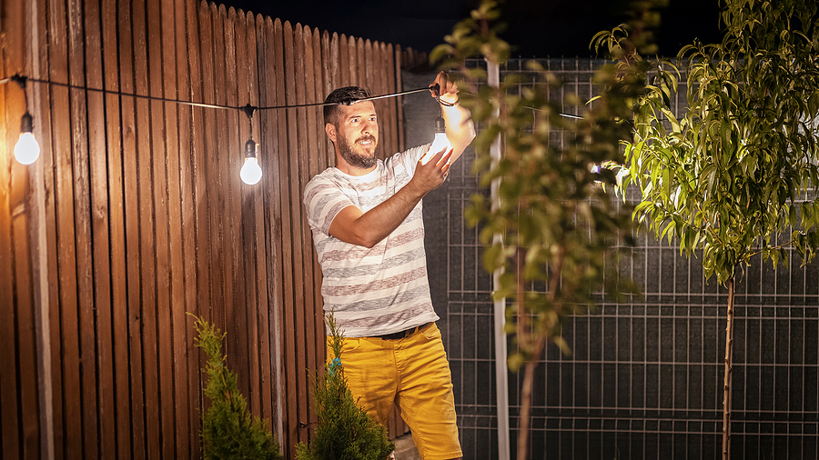 Man installing garden lighting in backyard