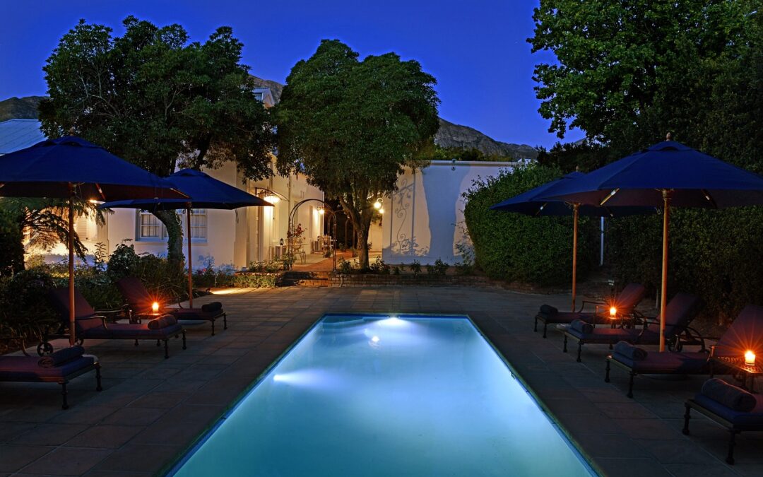 Backyard with terrace and pool area lit at sunset. Make Your Backyard Into A Vacation Destination with Lighting.