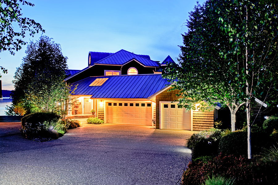 large luxury house with blue roof. Summer evening. Driveway lighting options.