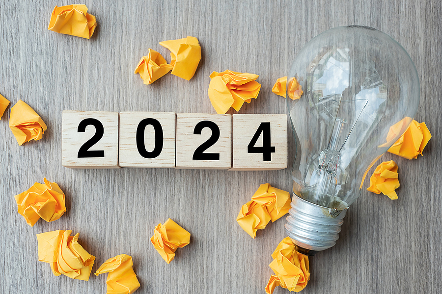 2024 text wood cube blocks and crumbled paper with lightbulb on wooden table background. New Year New Ideas, Creative, Innovation, Imagination, inspiration, Resolution, Strategy and goal concept. trends