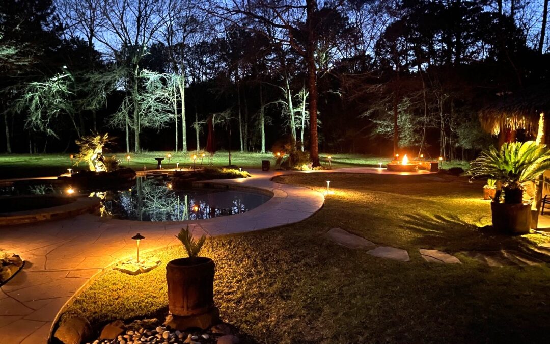A homes backyard walkway at dusk highlighting landscape lighting design.