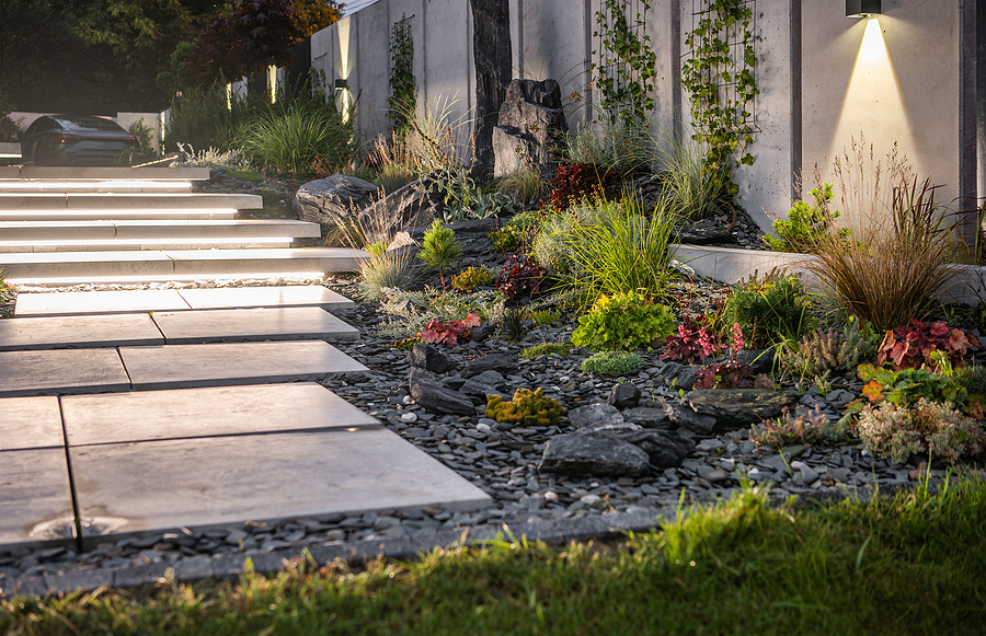 Illuminated backyard with LED lights highlighting the modern concrete wall and stairs, creating a beautifully lit and safe yard space.